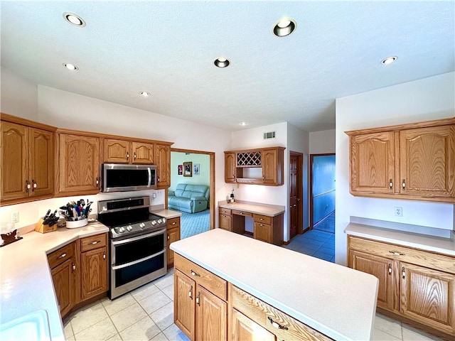 kitchen with light tile patterned floors, stainless steel appliances, light countertops, and recessed lighting