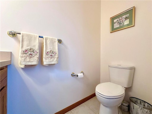 bathroom featuring toilet, tile patterned flooring, baseboards, and vanity