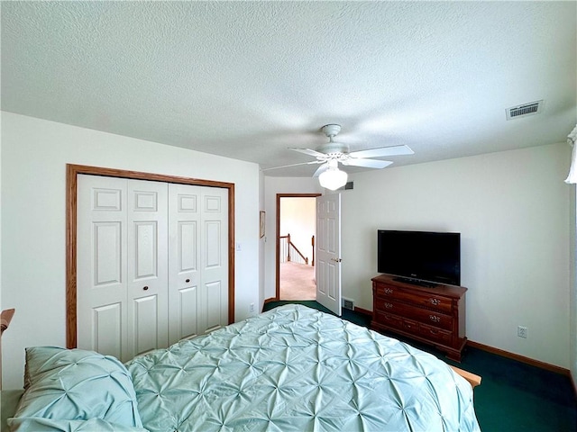 carpeted bedroom with baseboards, visible vents, ceiling fan, a textured ceiling, and a closet