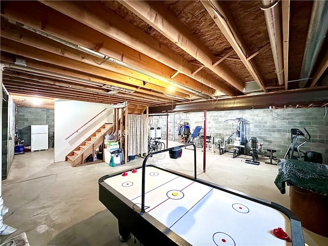 recreation room featuring unfinished concrete flooring