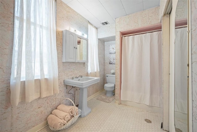 full bathroom featuring visible vents, toilet, a shower with curtain, tile patterned flooring, and a sink