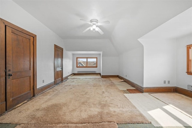 additional living space with lofted ceiling, ceiling fan, a baseboard radiator, light colored carpet, and baseboards