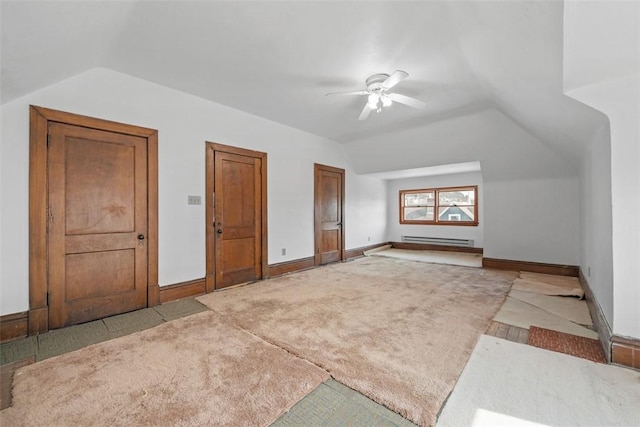 additional living space with vaulted ceiling, a baseboard heating unit, a ceiling fan, and baseboards