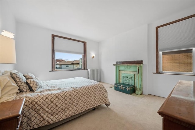 carpeted bedroom featuring radiator heating unit and a fireplace