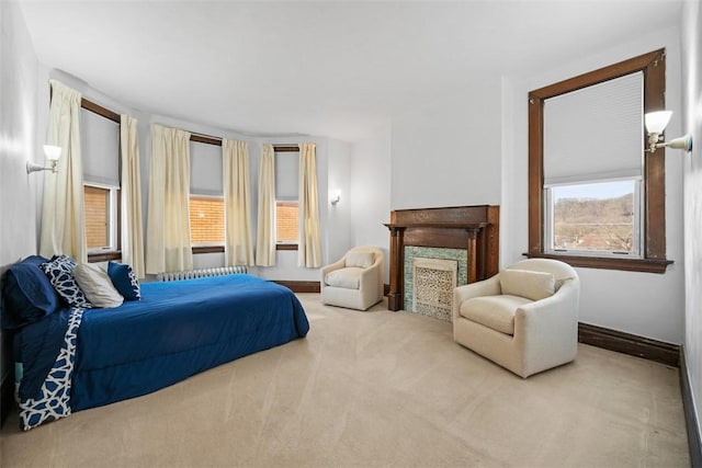 bedroom with carpet floors, a premium fireplace, and baseboards