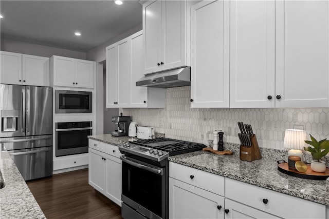 kitchen featuring under cabinet range hood, tasteful backsplash, appliances with stainless steel finishes, and white cabinets