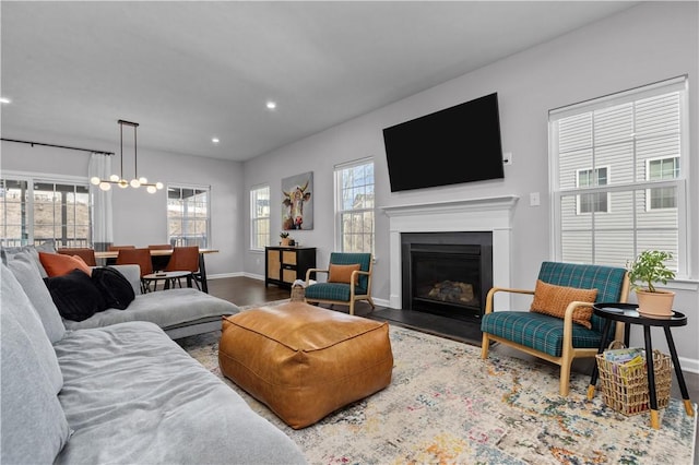 living room with a fireplace with flush hearth, a wealth of natural light, recessed lighting, and wood finished floors