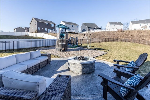 view of patio with an outdoor living space with a fire pit, a playground, a fenced backyard, and a residential view