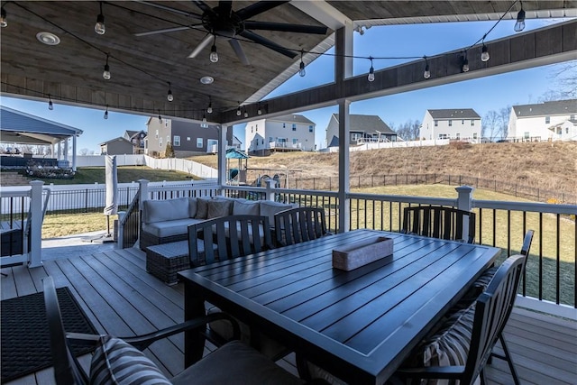 wooden terrace featuring a ceiling fan, a residential view, an outdoor hangout area, fence, and outdoor dining area