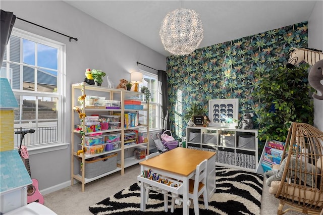 interior space featuring wallpapered walls, a notable chandelier, baseboards, and carpet flooring