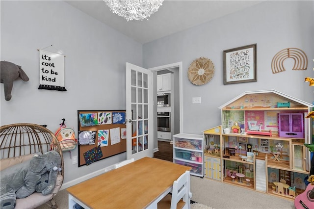 game room with carpet floors and an inviting chandelier