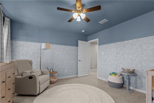 living area with baseboards, carpet flooring, visible vents, and a ceiling fan