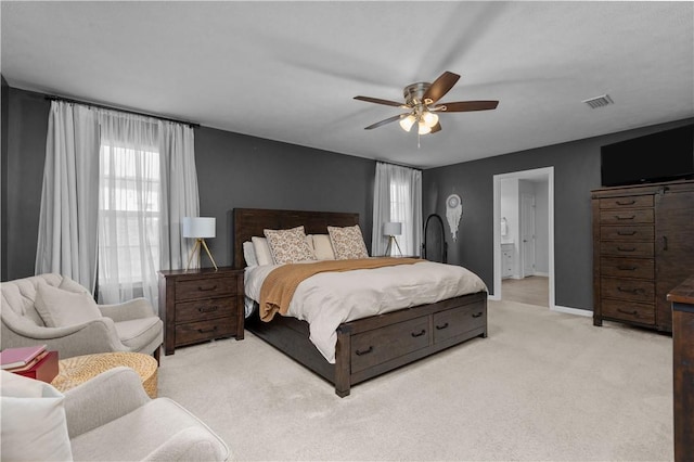 bedroom with light carpet, baseboards, visible vents, connected bathroom, and ceiling fan