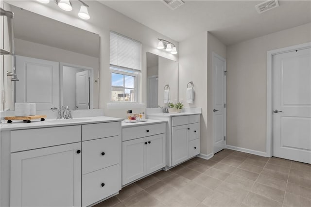 bathroom with tile patterned flooring, visible vents, vanity, and baseboards