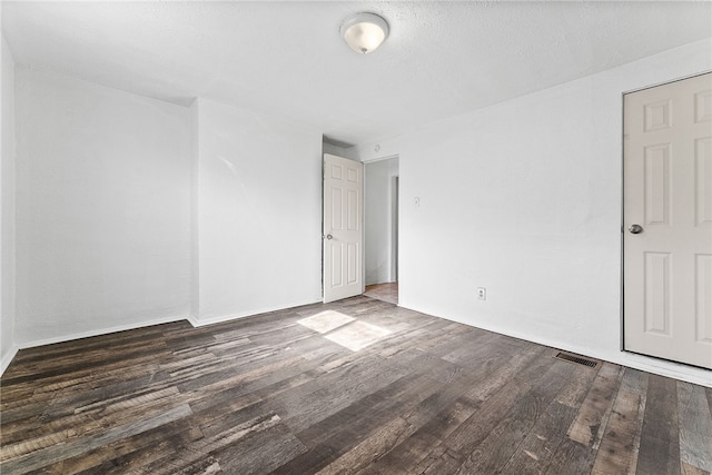 empty room featuring visible vents and wood finished floors