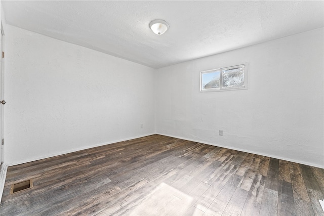 unfurnished room with visible vents, a textured ceiling, and wood finished floors