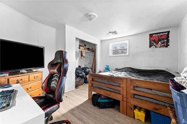 bedroom featuring ornamental molding, wood finished floors, and visible vents