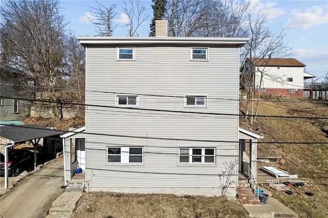 rear view of property featuring a chimney