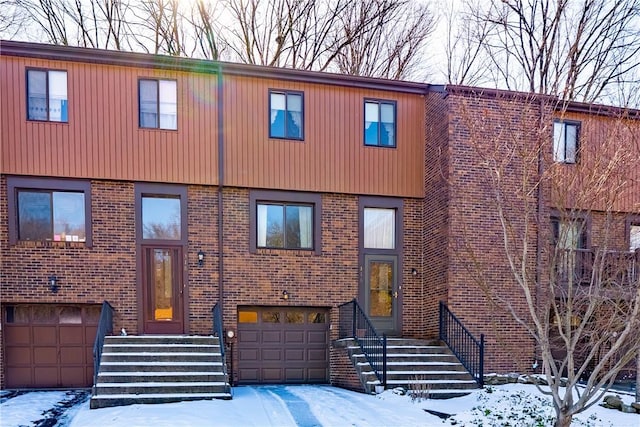 multi unit property featuring a garage and brick siding