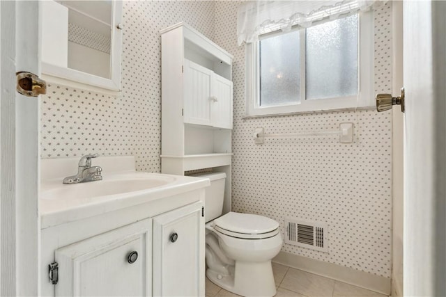 half bathroom featuring visible vents, toilet, vanity, tile patterned flooring, and wallpapered walls