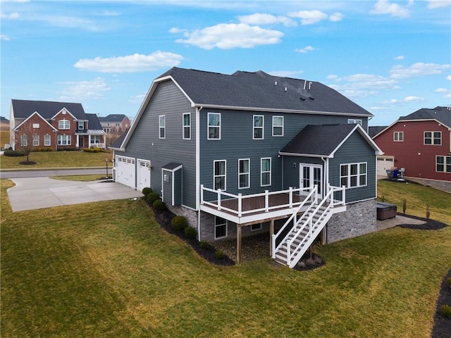 rear view of house featuring a garage, concrete driveway, a yard, and stairs