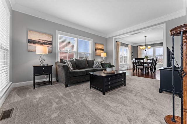 living area featuring crown molding, light colored carpet, visible vents, and a notable chandelier