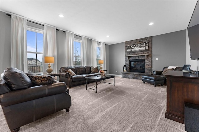 living area featuring light carpet, recessed lighting, baseboards, and a stone fireplace