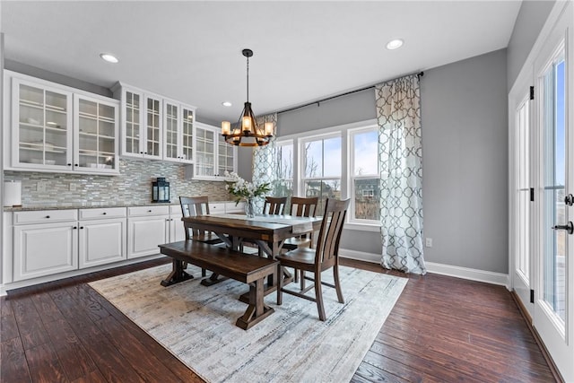 dining room with recessed lighting, dark wood-style flooring, an inviting chandelier, and baseboards