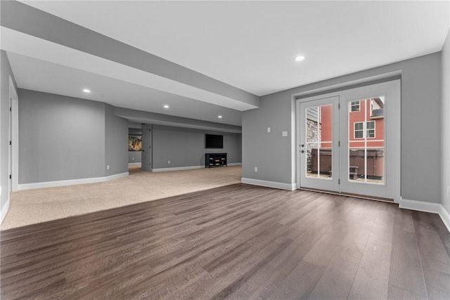 unfurnished living room with baseboards, dark wood-style flooring, and recessed lighting