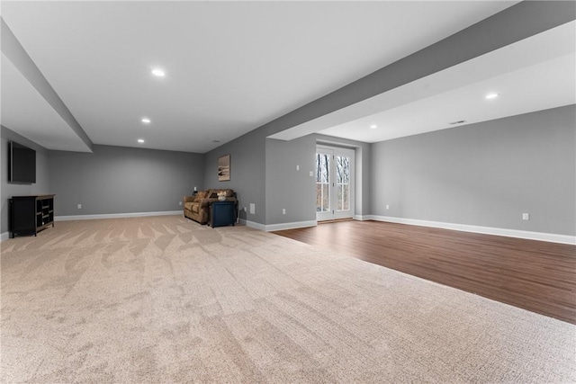 below grade area with light wood-style flooring, recessed lighting, light colored carpet, and baseboards