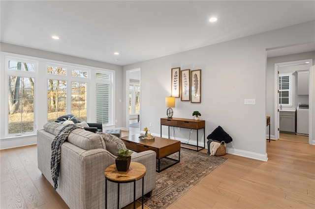 living room featuring washer / dryer, recessed lighting, light wood-style floors, and baseboards