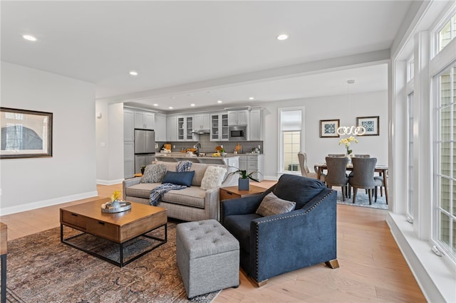 living area with baseboards, light wood-style flooring, and recessed lighting