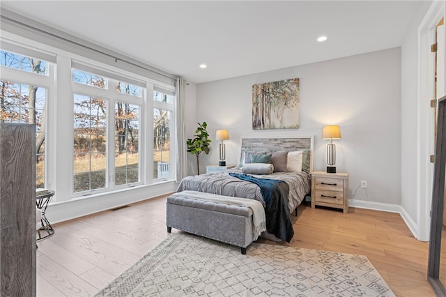 bedroom featuring light wood-type flooring, multiple windows, and visible vents