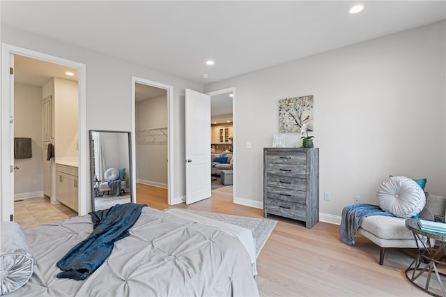 bedroom featuring baseboards, a spacious closet, light wood-type flooring, a closet, and recessed lighting