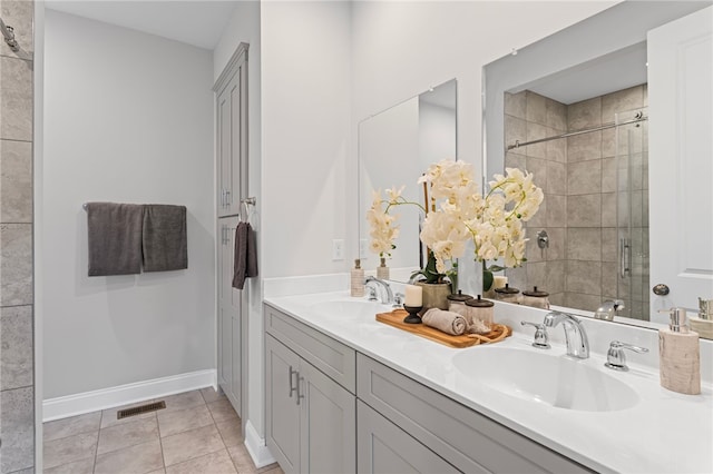 bathroom with visible vents, a sink, a shower stall, and tile patterned floors