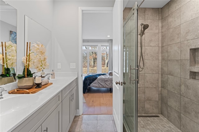 bathroom with a stall shower, tile patterned floors, a sink, and ensuite bathroom