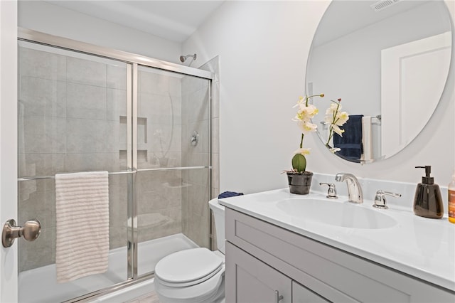 full bath featuring tiled shower, vanity, and toilet