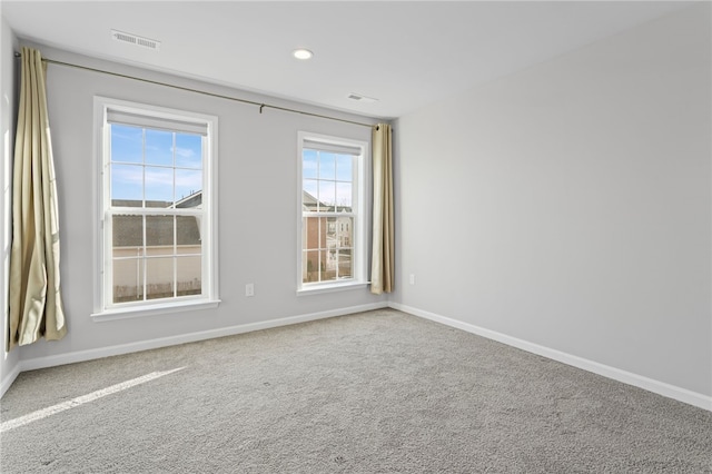 spare room featuring carpet floors, baseboards, visible vents, and recessed lighting