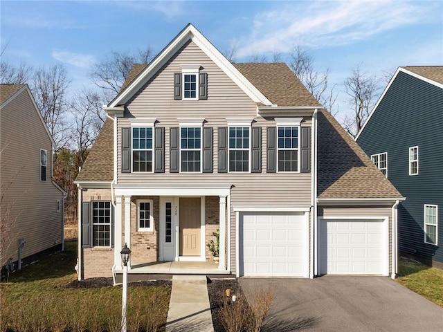 traditional home featuring aphalt driveway, brick siding, a shingled roof, and a garage