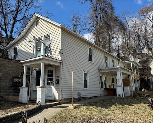 view of property exterior with covered porch and fence