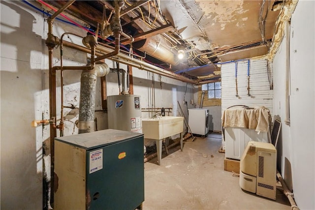 basement with water heater, washer / clothes dryer, and a sink