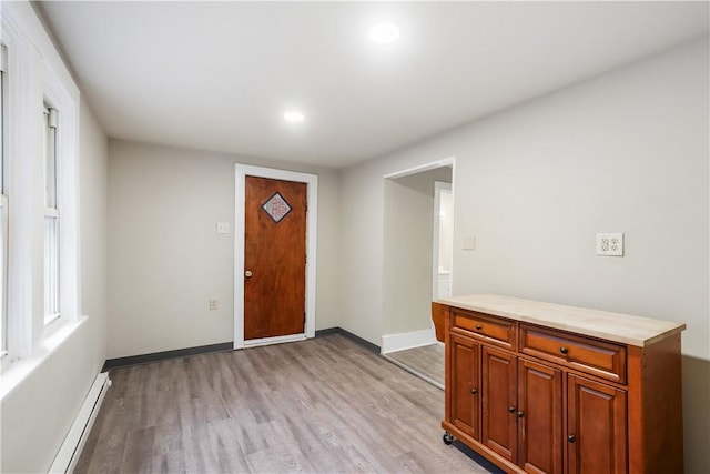 entryway with a baseboard heating unit, recessed lighting, baseboards, and light wood finished floors