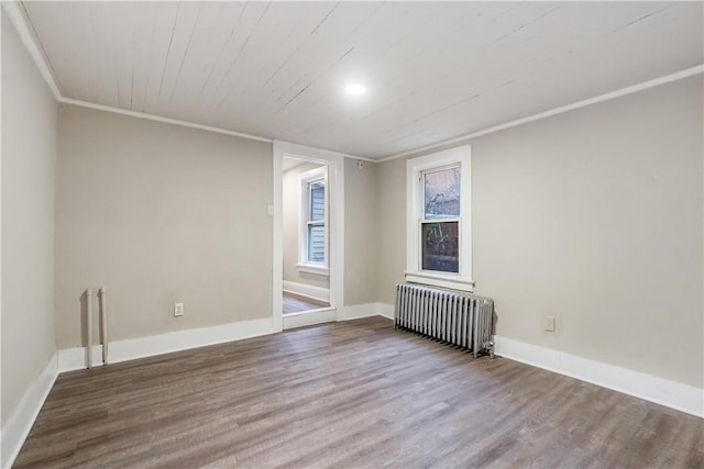 unfurnished room featuring baseboards, wooden ceiling, radiator heating unit, wood finished floors, and crown molding