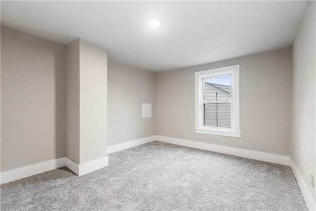 empty room featuring carpet flooring and baseboards