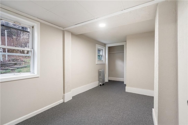 interior space featuring carpet, radiator, and baseboards