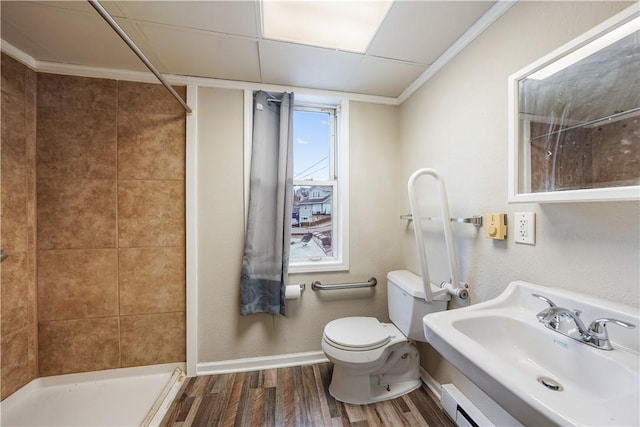 bathroom with toilet, wood finished floors, a sink, baseboards, and a stall shower