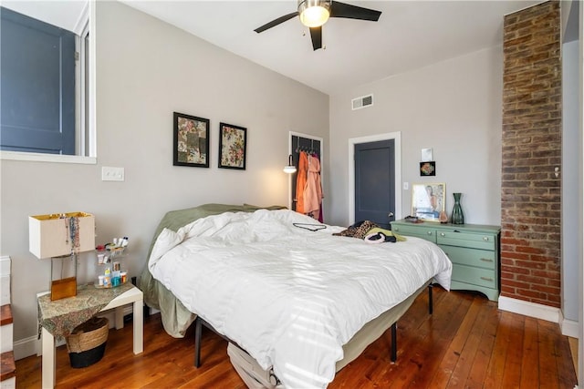 bedroom featuring a ceiling fan, baseboards, visible vents, and hardwood / wood-style floors