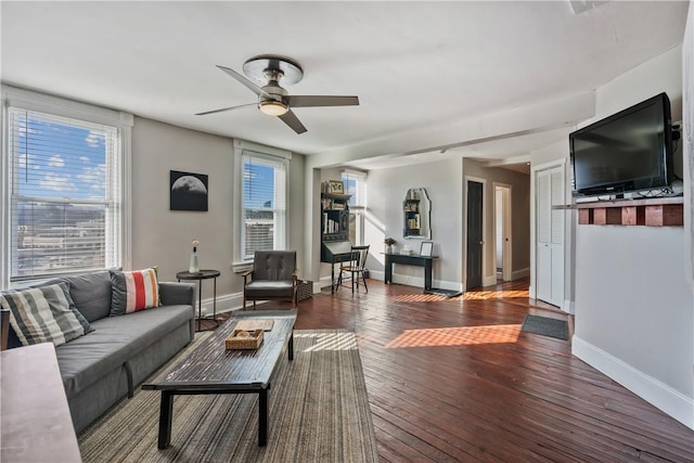 living area with a ceiling fan, baseboards, and hardwood / wood-style floors