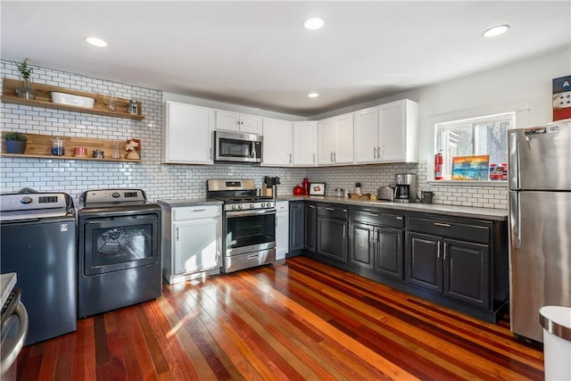 kitchen featuring dark wood finished floors, stainless steel appliances, backsplash, white cabinetry, and separate washer and dryer