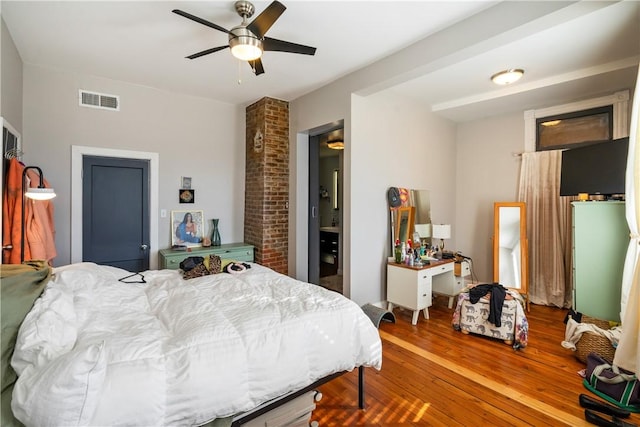 bedroom featuring ceiling fan, wood finished floors, and visible vents